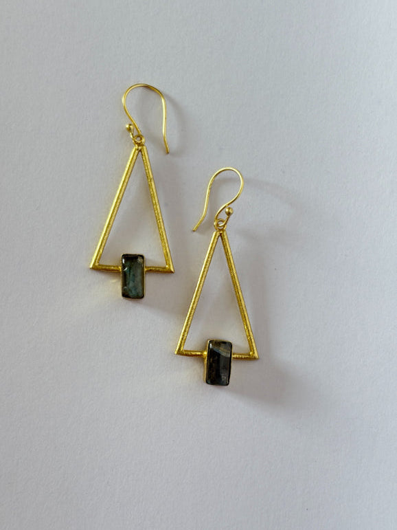 Gold triangle-shaped earrings with green stones on a light gray background