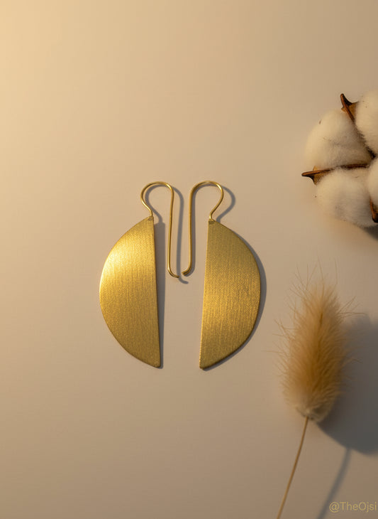 Gold earrings on a light gray background