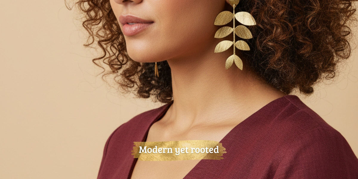 Woman with curly hair wearing long gold-plated leaf earrings from Ojsi